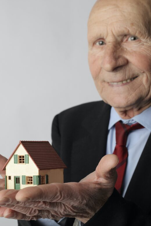 Photo: Older man holding a home in his hands