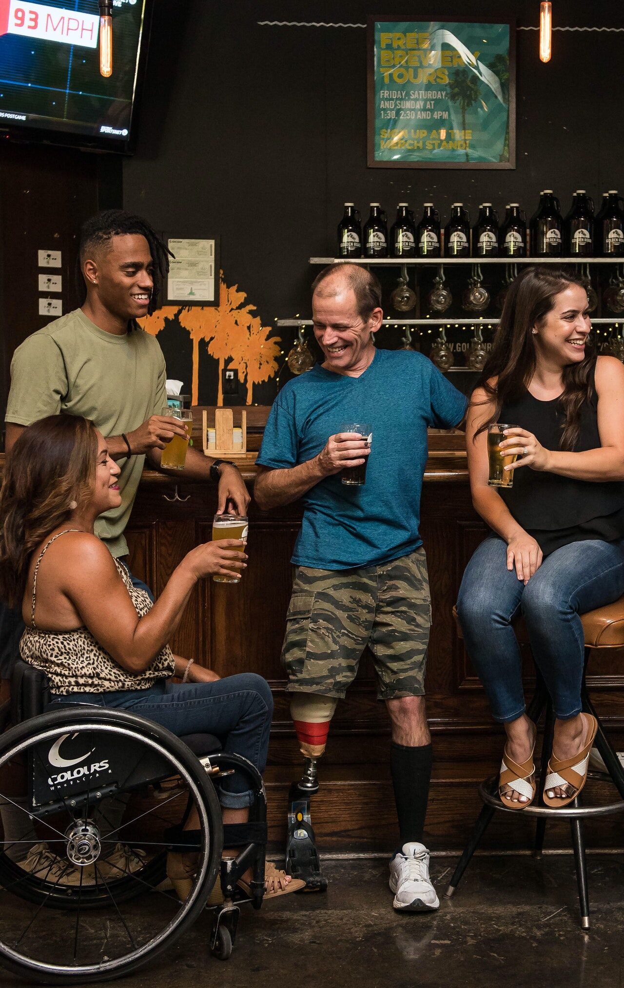 Photo: four adults, one using a wheelchair at a bar