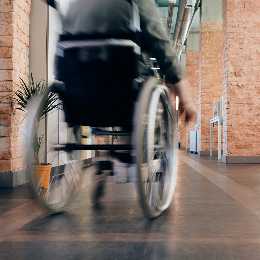 Photo: person in wheelchair rolling forward down a hallway